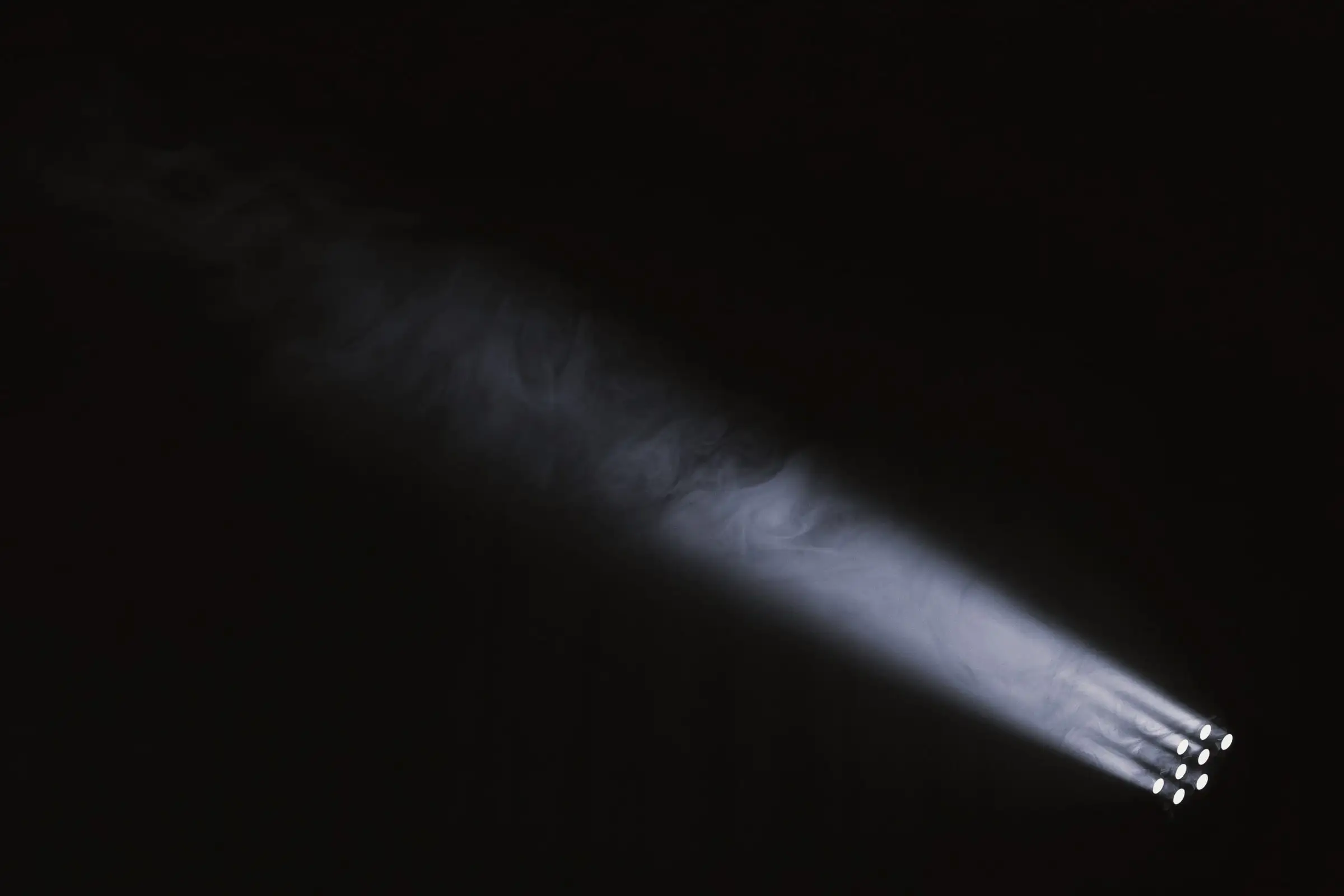 Single stage light beam cutting diagonally through haze against a black background